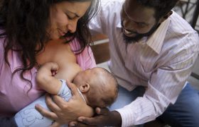 high-angle-smiley-woman-breastfeeding